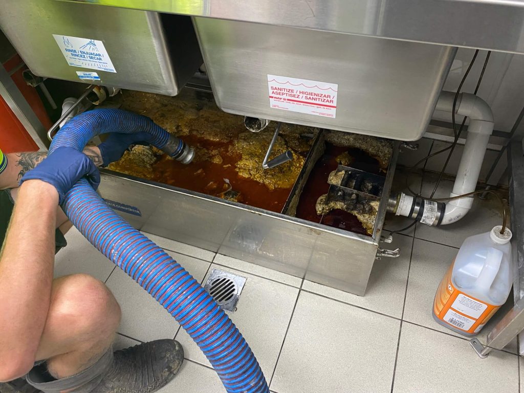 Grease trap pumping service by The Grease Company in a busy commercial kitchen