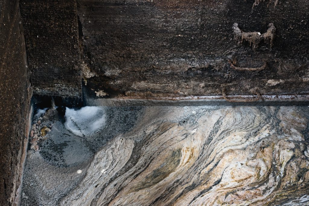Sticky accumulated grease inside a commercial grease trap showing how to clean a grease trap properly.