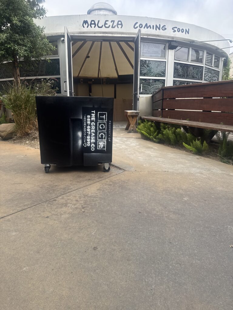 Newly replaced grease trap installed behind restaurant after removing old unit.