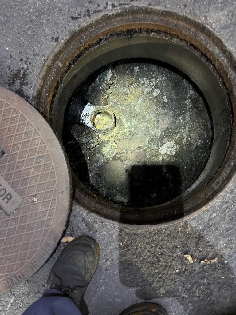 Open underground grease trap during service inspection and grease trap replacement in commercial kitchen system.