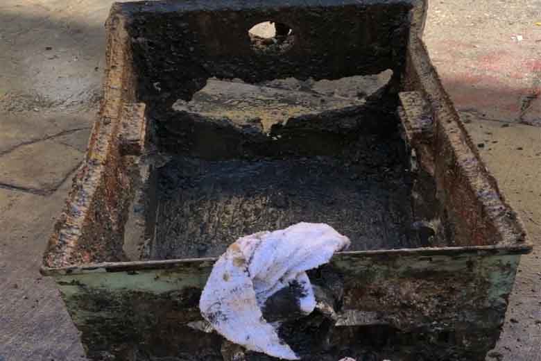 Severely damaged and overflowing grease trap requiring emergency grease trap maintenance and restoration