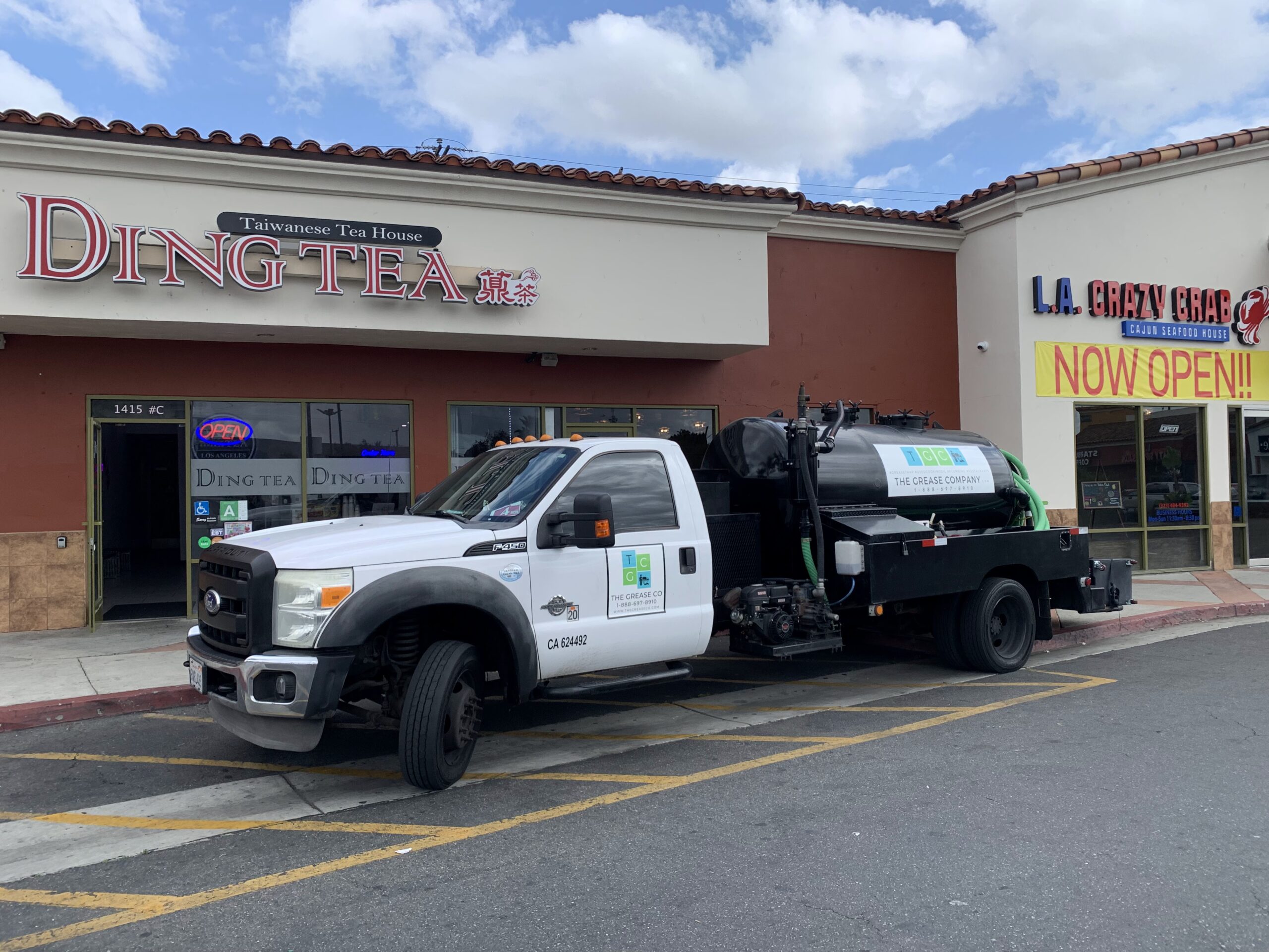 Service truck of The Grease Company outside restaurant providing grease trap installation