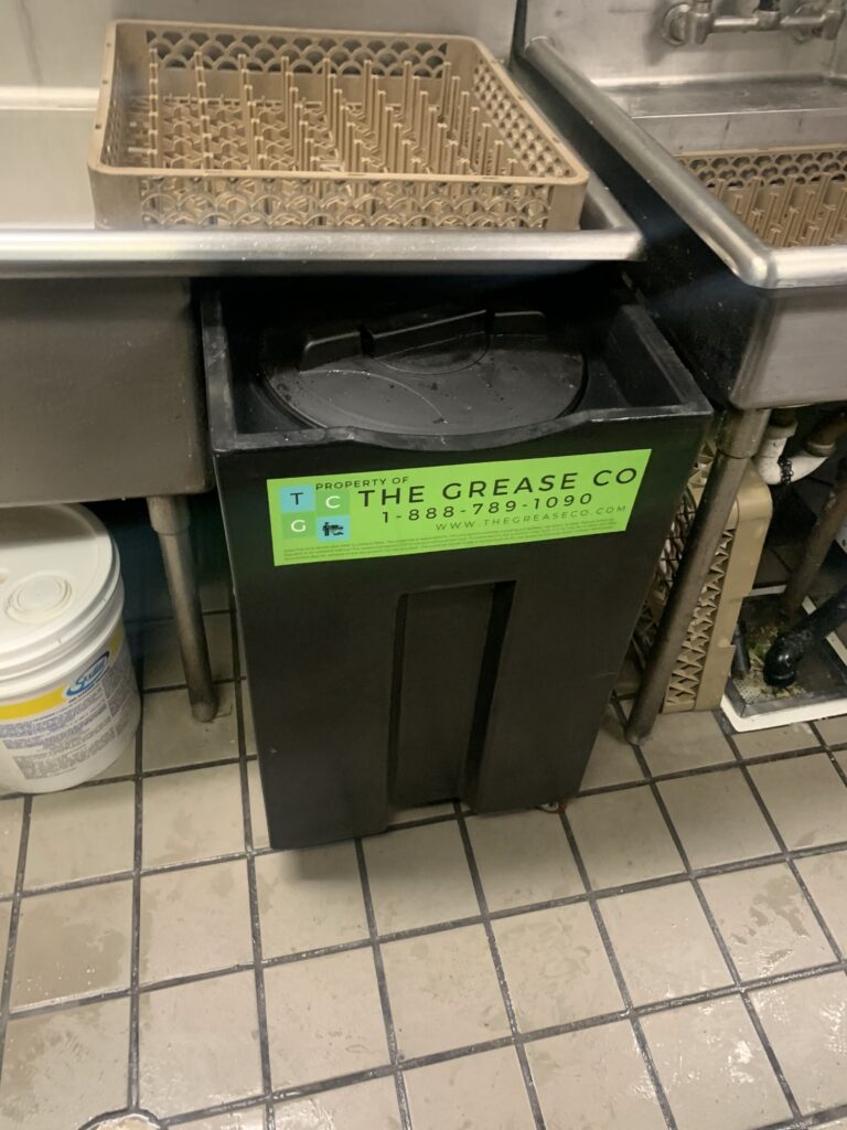 Grease trap smell issue in an under-sink separator in a commercial kitchen caused by grease, food solids, and wastewater buildup.