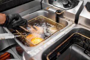 Restaurant deep fryer in a commercial kitchen where grease spill clean up is needed