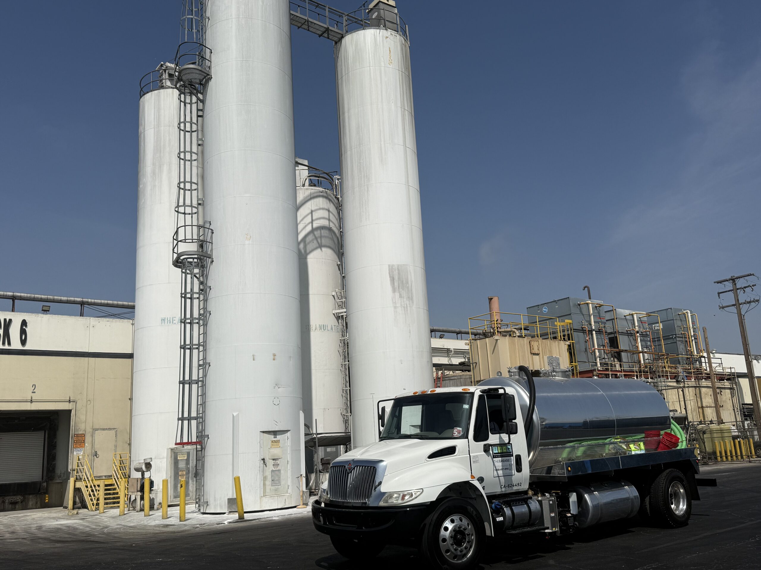 Recycling used cooking oil with Grease Company truck at facility
