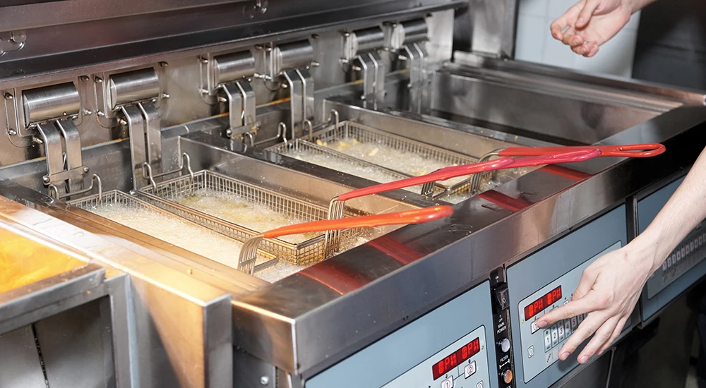 Commercial deep fryer producing used fryer oil for collection
